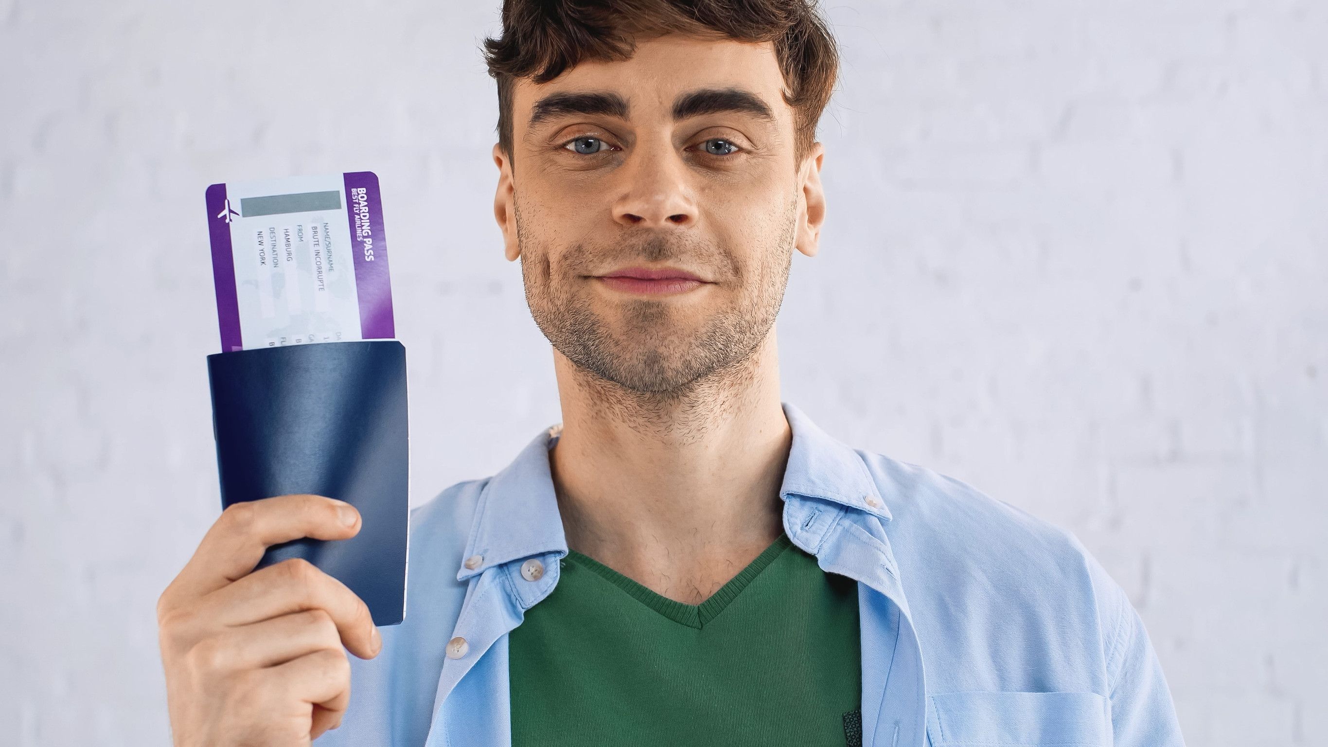 Cheerful Man In Blue Shirt Holding Passport And Tickets