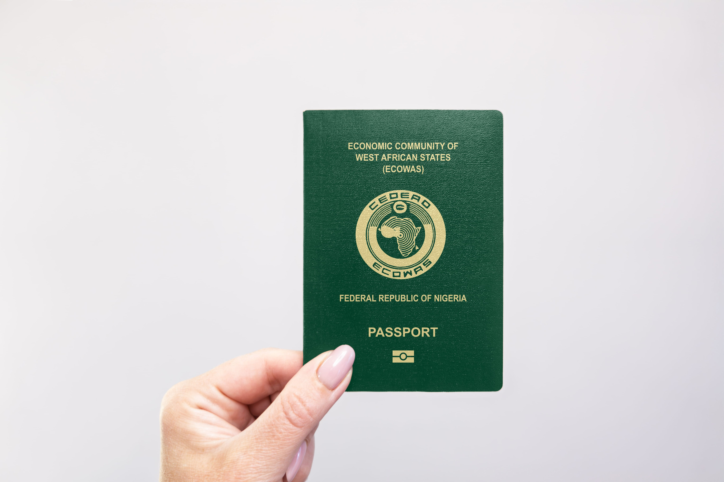 Nigeria Passport Held In Hand Against A Plain