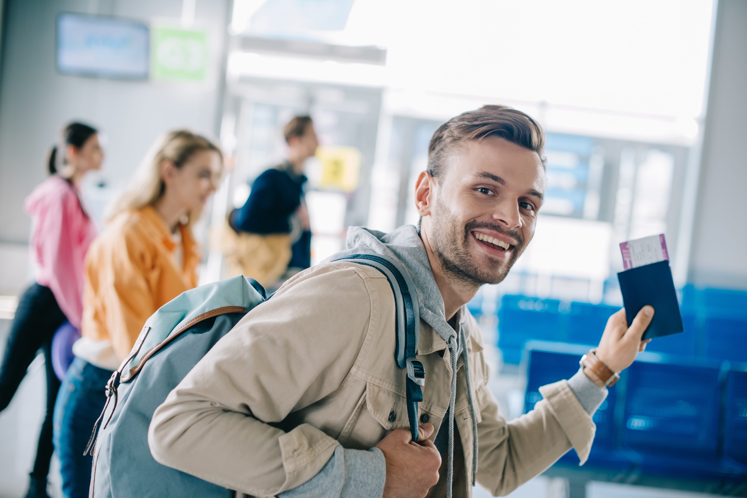 Young Man Holding Passport And Smiling